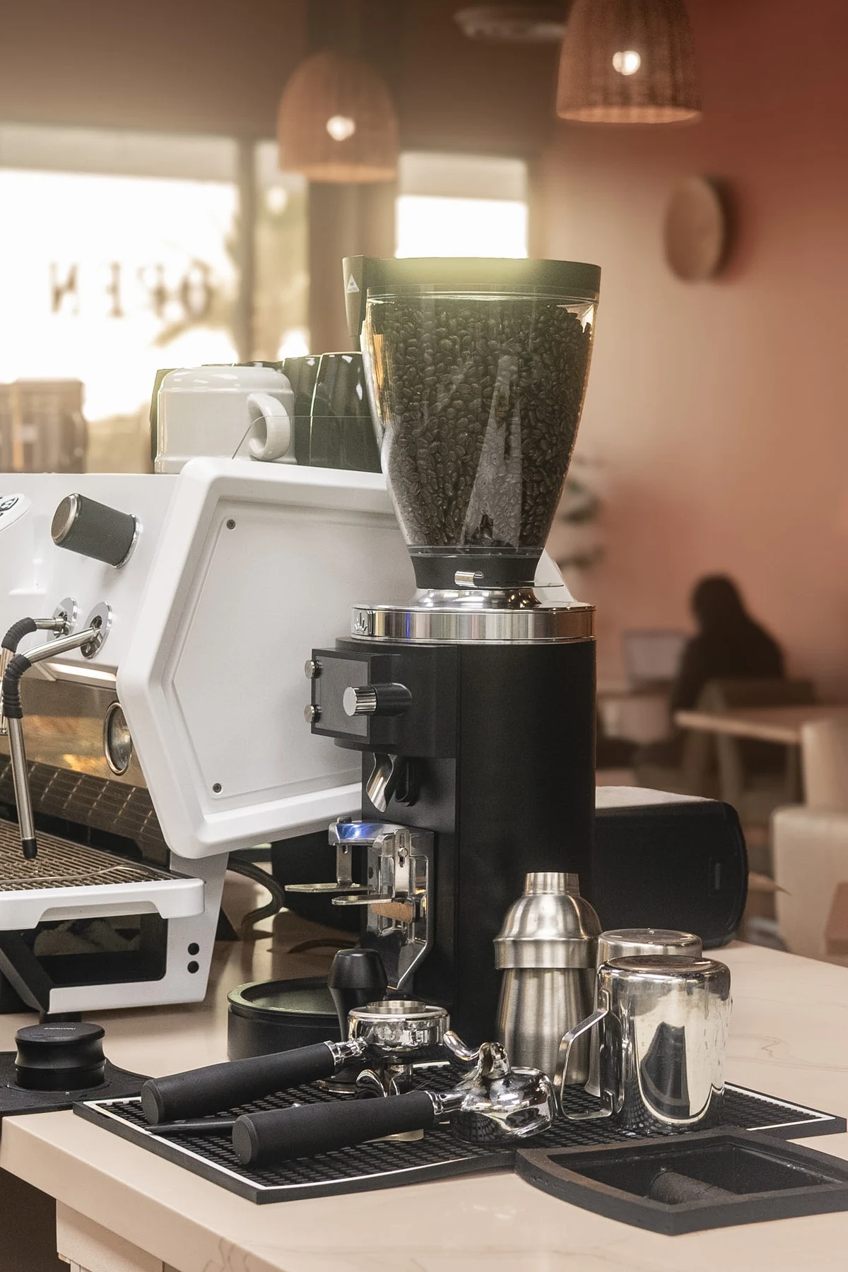 Elura’s espresso machine, coffee grinder, and barista tools in the warm café light