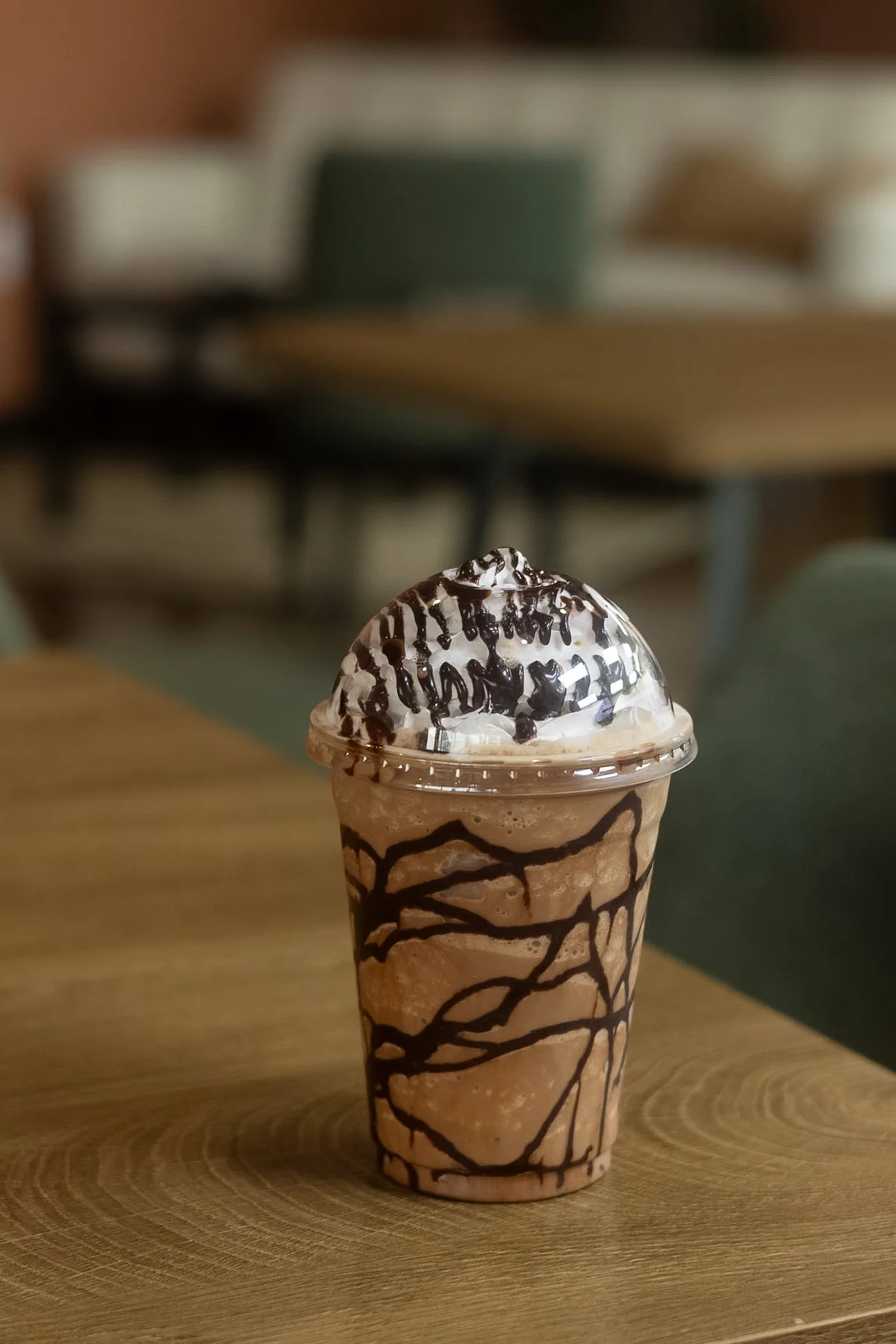 Chocolate-drizzled blended drink topped with whipped cream